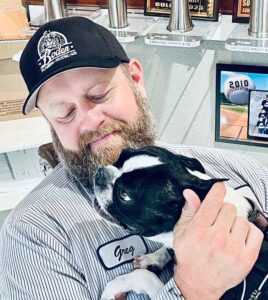 A Boden Plumbing employee cuddling a cute pooch.